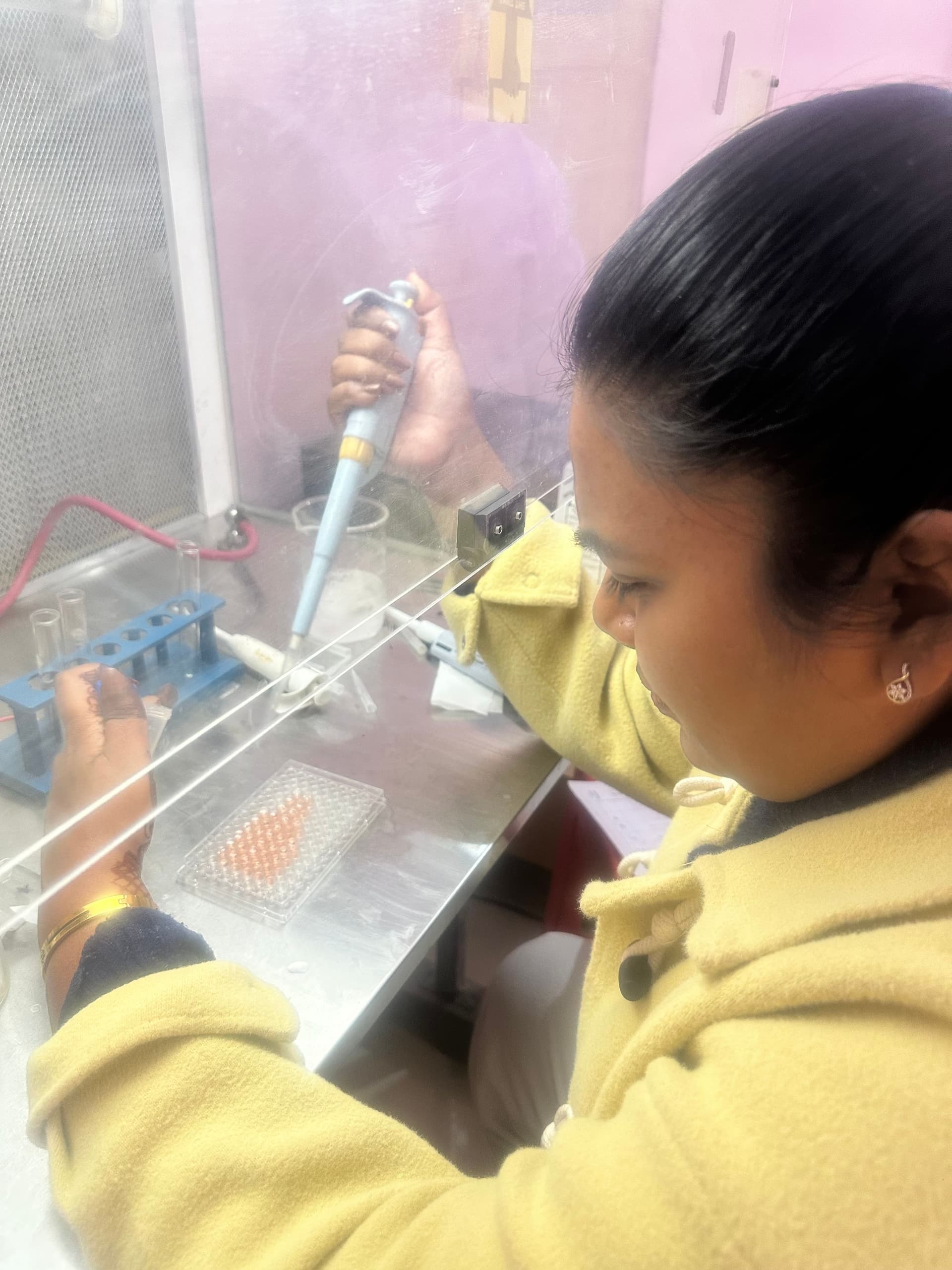 Researcher performing a sterile transfer in a lab cabinet