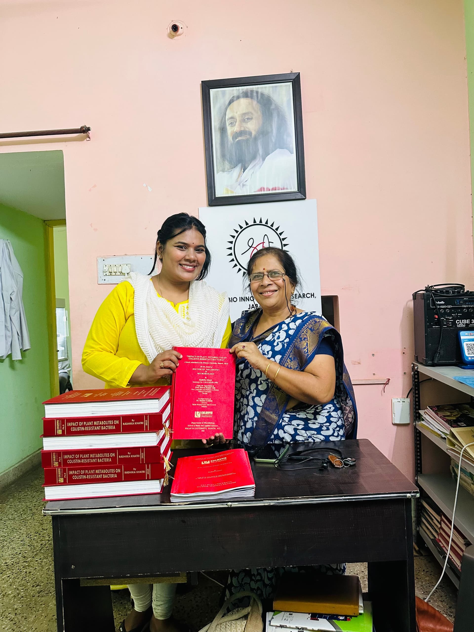 Two researchers posing with scientific books in an office